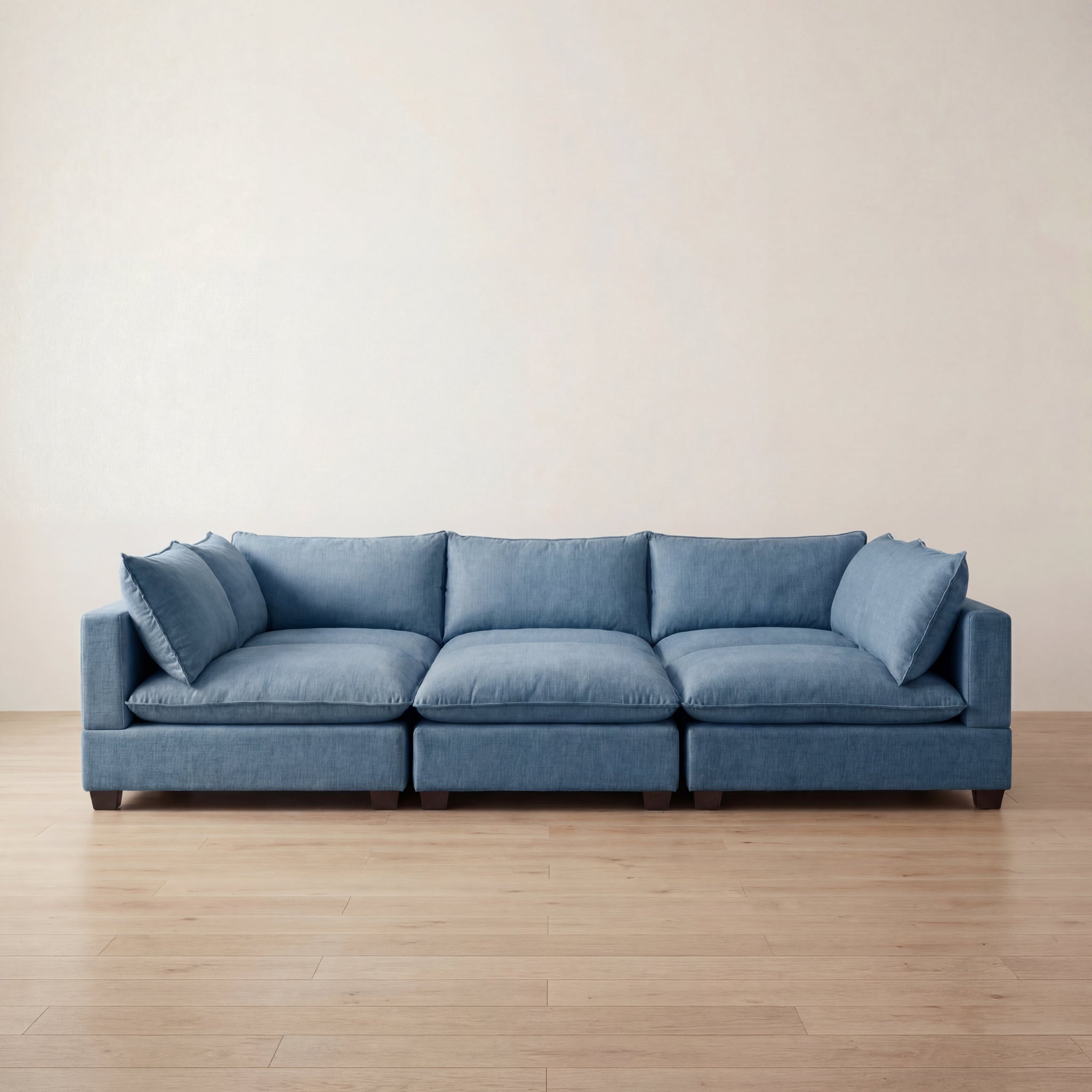 Blue sofa on a wooden floor with a plain wall background