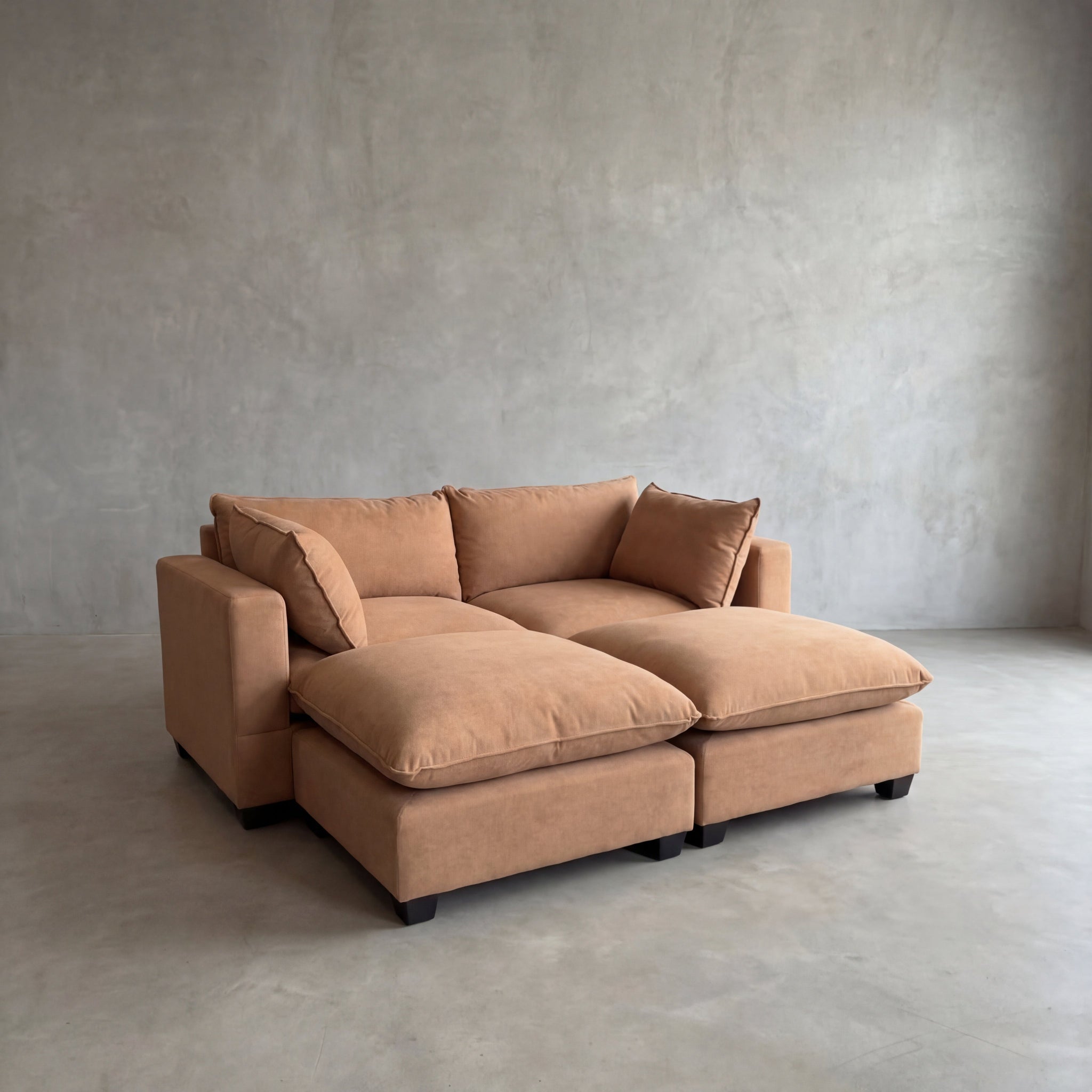Brown sectional sofa in a minimalistic room with gray walls and floor.