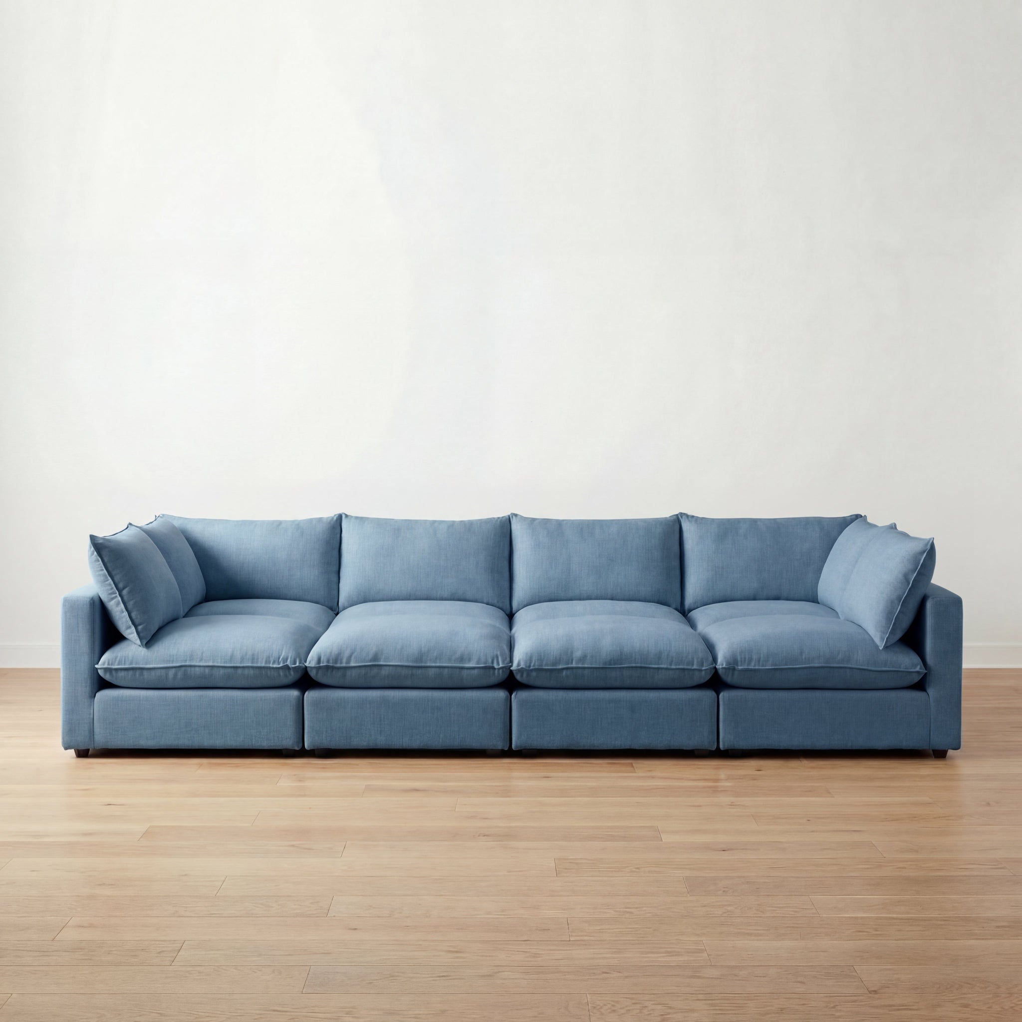 Blue pit sectional on a wooden floor with a white wall background