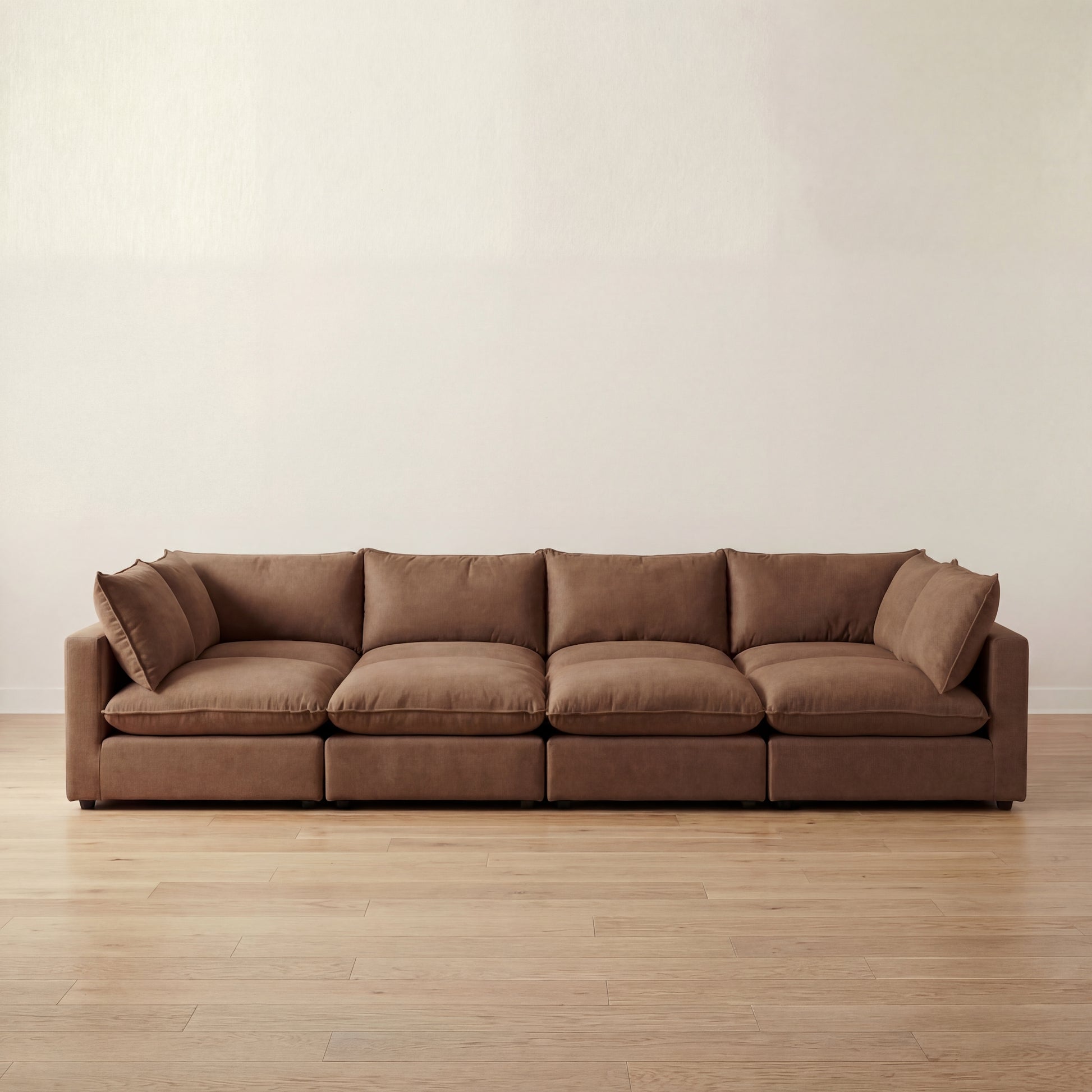 Brown large pit sectional sofa on a wooden floor with a plain wall background
