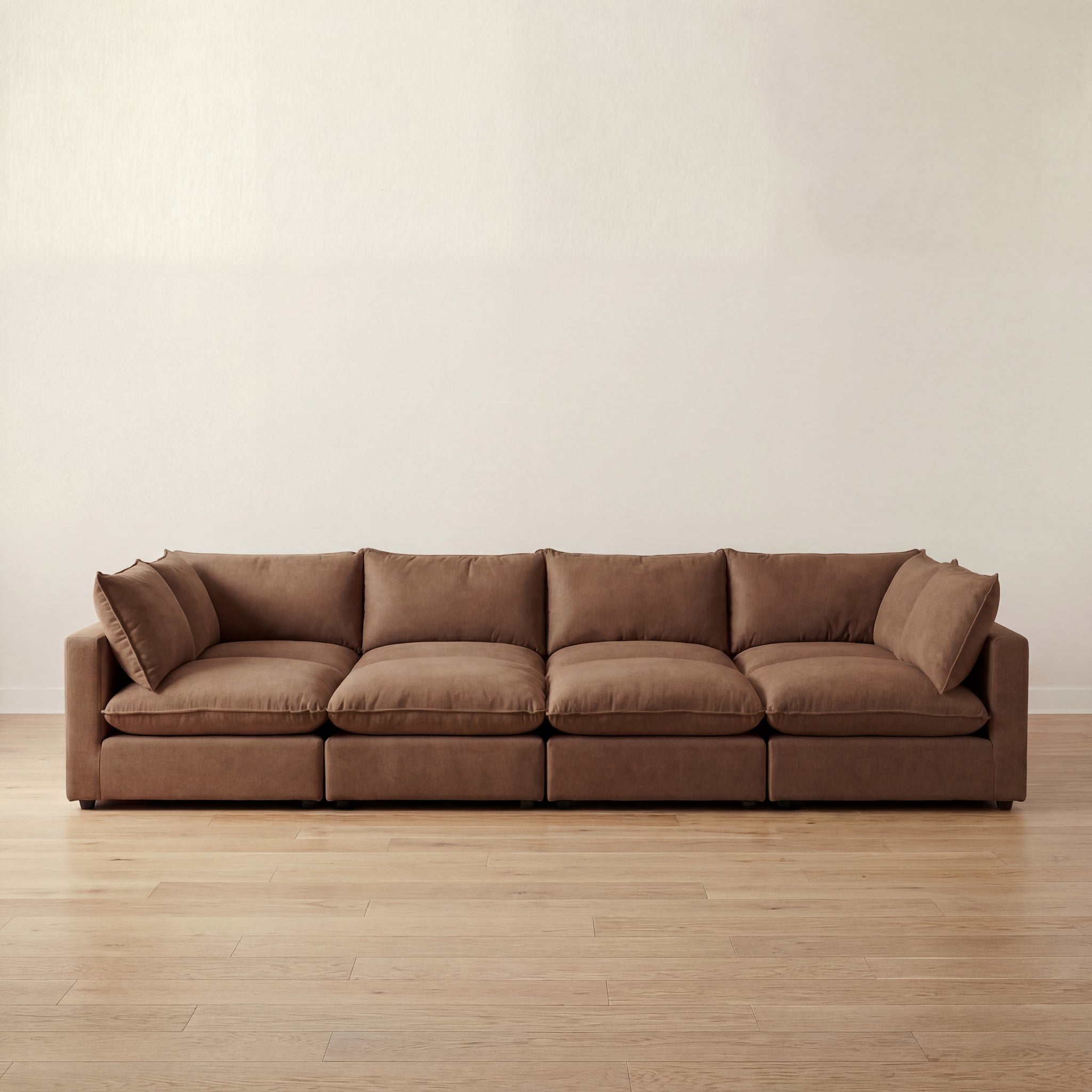 Brown large pit sectional sofa on a wooden floor with a plain wall background